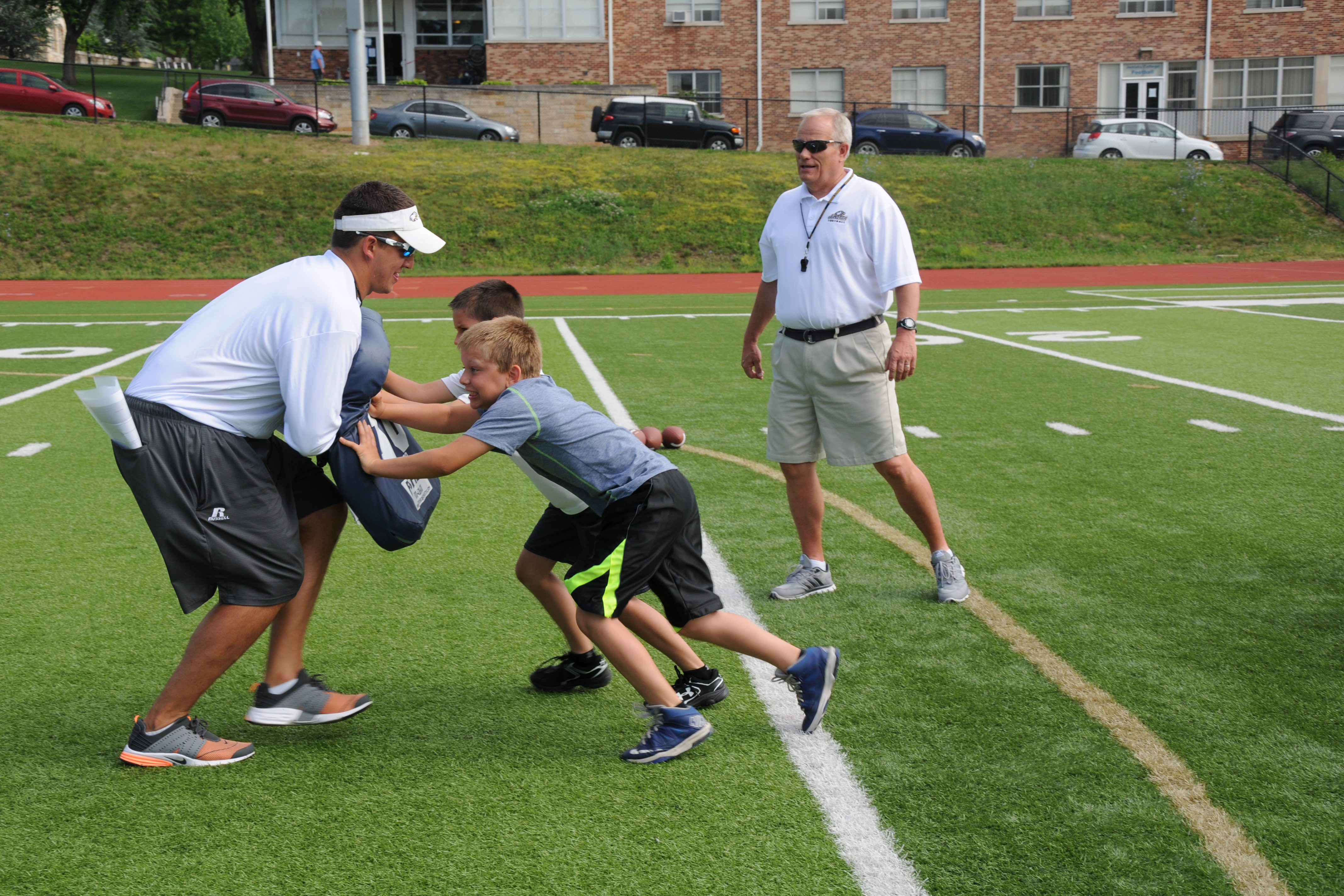 Coach Tim Launz '80 works with a youth football camp.